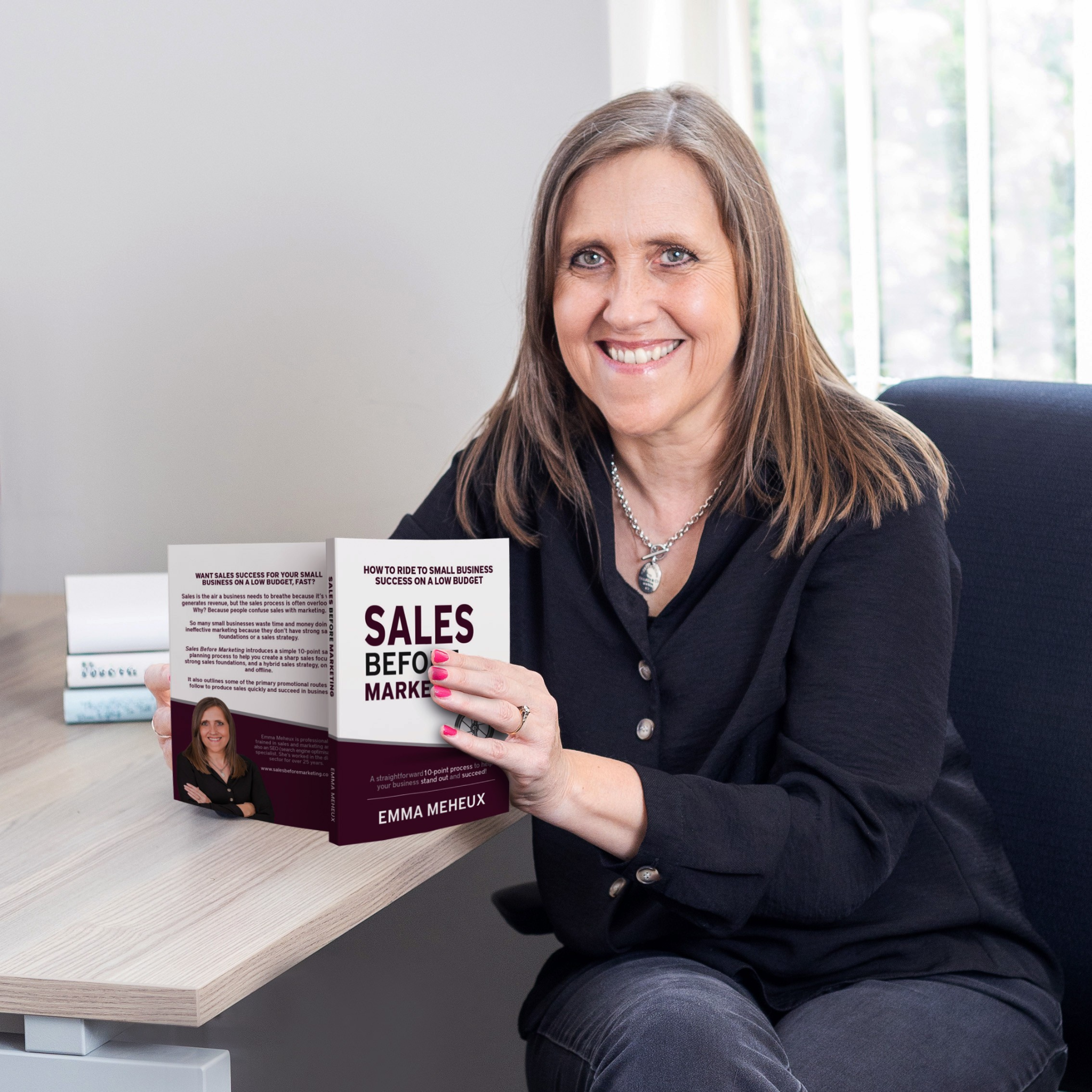 Emma holding book at her desk